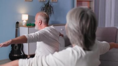 Sağlık ve ev içi egzersizleri, spor yapan sporcu emeklilerin portresi evde spor salonunda oturan aktif yaşlı karı-koca.