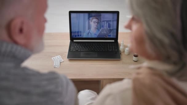 Eski hastalar, modern teknolojileri kullanarak video iletişimi yoluyla doktorlara danışmanlık yapıyorlar. Yaşlı erkek ve kadın, omuzlarının üzerinde oturuyorlar. — Stok video
