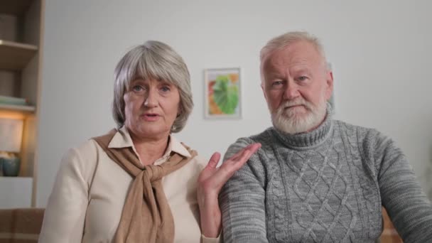 Pensionistas hablan y muestran píldoras en la webcam, retrato de los abuelos de pelo gris comunicarse con un médico a través de Internet en casa — Vídeo de stock
