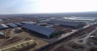 Kırsal alandaki devasa güneş enerjili çiftliğin havadan çekilmiş görüntüleri, çiftlik hayvanları binaları ve saman balyaları.