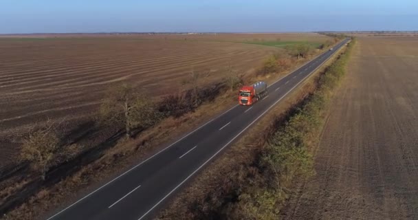 Krajobraz, widok z lotu ptaka na transport drogowy towarów z cysterną na mleko jadącą po drogach w pobliżu pola rolniczego — Wideo stockowe