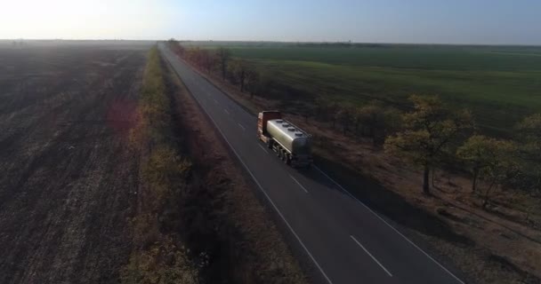 Süt teslimatı, tank kamyonunun havadan görünüşü çiftlikten ayrılıp müşterilere doğru yol boyunca gidiyor. — Stok video