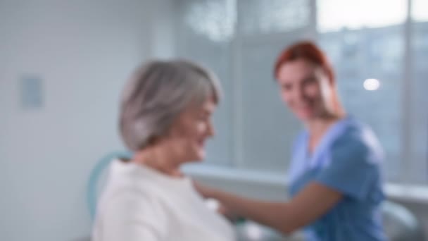 Herstelbehandeling, vrouwelijke fysiotherapeut die oude patiëntenarmen helpt bewegen met halters, gezondheidszorg en zorg — Stockvideo