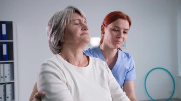 Rehabilitation für Patienten, Krankenschwester hilft alten Frauen, Hanteln zu Hause zu heben, Genesung von Verletzungen — Stockvideo