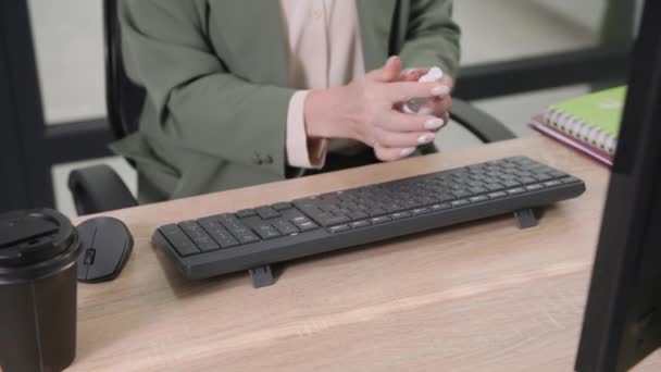 Pandemia, jovem trabalhador de escritório trabalha no computador e trata a superfície da mesa e teclado com um anti-séptico para prevenir o vírus e infecção, close-up — Vídeo de Stock