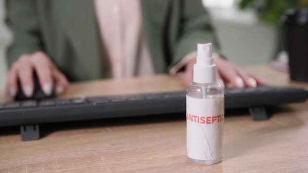 Pandemie, antisepticum op bureau van vrouwelijke werknemer voor oppervlaktebehandeling tegen virus en infectie, close-up — Stockvideo
