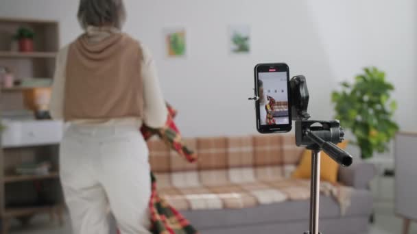 Pensionering, glada äldre par skjuter underhållning innehåll för sociala nätverk på smartphone kamera och visa roligt trick i mysiga rum — Stockvideo