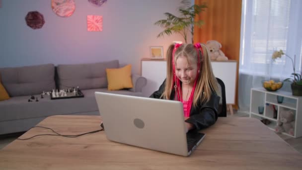 現代の子供の娯楽、ピンクのブライドを持つスタイリッシュな女性のティーンエイジャーは、部屋のテーブルに座ってコンピュータ上でオンラインゲームをプレイ — ストック動画