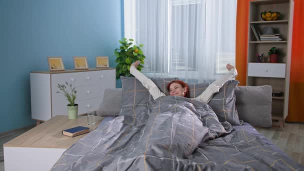Szczęśliwa kobieta po przebudzeniu ze snu, pije czystą zimną wodę, aby utrzymać równowagę wodną w ciele siedząc w łóżku, uśmiechając się i patrząc w kamerę — Wideo stockowe