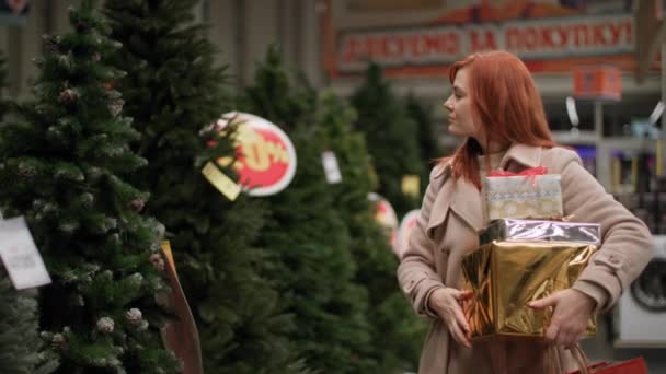 Perakende, genç kadın kış tatili için evde yapay bir Noel ağacı seçiyor süpermarkette mevsimlik nakliyat sırasında, metin klipli cümlede beliriyor: alışveriş için teşekkürler — Stok video