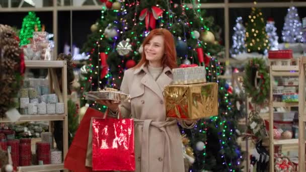 Detailhandel, glimlachende jonge vrouw verheugt zich met korting gekocht geschenken voor familie en vrienden voor vakantie in warenhuis — Stockvideo