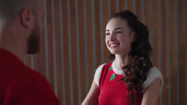 Weihnachtsfeier: Liebendes Ehepaar tanzt an Silvester in roten Kostümen am Weihnachtsbaum — Stockvideo