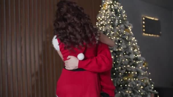 Silvesterparty, glückliche Eheleute haben Spaß beim gemeinsamen Tanzen im Familienurlaub in der Nähe des dekorativen Weihnachtsbaums zu Hause — Stockvideo
