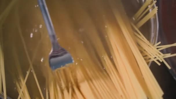 Vaření těstoviny, špagety se vaří v hrnci horké vody pro rodinnou večeři, detailní záběr — Stock video