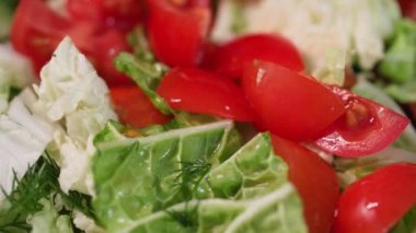 Sağlıklı yiyecekler, olgun domatesler zeytin yağıyla yağlanmış taze kokulu sebze salatasının içine düşer.