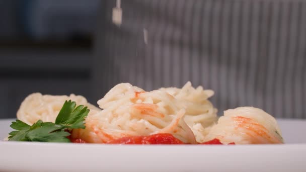 Yemek pişirme süreci, servis etmeden önce üzerine rendelenmiş peynir serpiştirilmiş beyaz tabakta soslu lezzetli spagetti, yakın çekim. — Stok video
