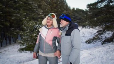 Ormanda romantik kış yürüyüşleri, gri saçlı eşler ormanda birlikte dolaşarak zaman geçirirler.