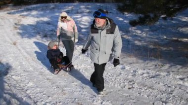 Büyük anne ve büyük baba torunlarını kızakla gezdiriyorlar. Yaşlı bir çift ve bir oğlan çocuğu hafta sonunu aktif olarak kış ormanlarında geçiriyorlar.