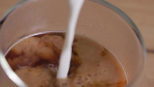咖啡饮料，新鲜的泡沫牛奶倒入一杯咖啡中，特写 — 图库视频影像