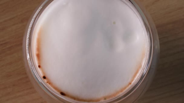 Café con leche, gotas de leche batida cayendo en una bebida de café, vista superior — Vídeo de stock