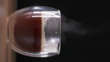 Cappuccino veya latte, sütlü sürahide sıcak kahveye konur. Lezzetli bir içecek hazırlamak için, dikey ekran.