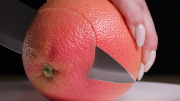 Šťavnaté zralé zdravé grapefruity nakrájené na kulaté plátky nožem, detailní záběr — Stock video