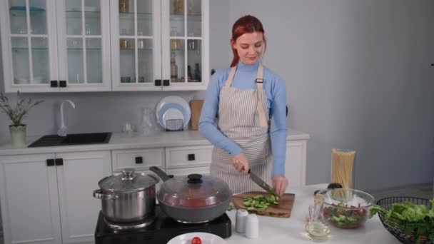 Comida saludable, mujer joven preparando comida vegetariana y cortando verduras frescas crudas en la tabla de cortar de pie en la cocina en casa — Vídeos de Stock