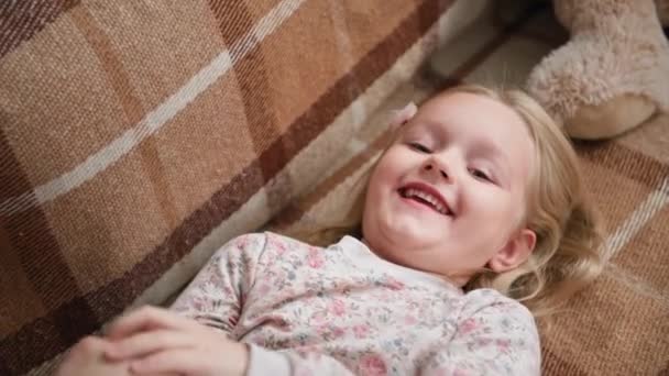 Ritratti di un'adorabile ragazza carina che si diverte con la mamma sul divano mentre sta insieme a casa, primo piano — Video Stock