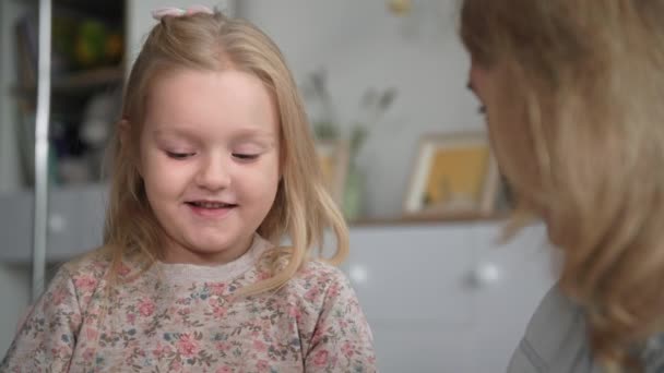 Дитинство, чарівна жіноча дитина розмовляє зі своєю коханою мамою, висячи в затишній кімнаті вдома — стокове відео