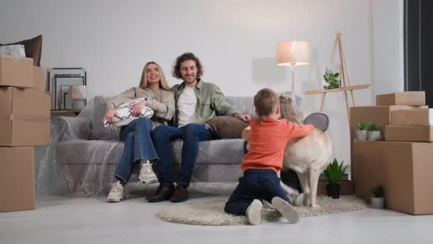 Familia Divirtiéndose Juntos Apartamento Nuevo Padres Hijos Jugando Con Mascotas — Vídeo de stock
