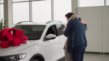 Bir araba alır, aşık bir adam gözlerini karısına kapatır ve arabadan yeni bir araba verir, mutlu bir kadın kocaya sarılır ve hediyeyle sevinir.