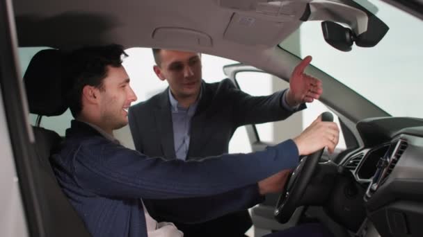 Успішний Чоловік Клієнт Оглядає Новий Автомобіль Разом Автодилером Автосалоні — стокове відео