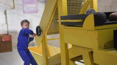 children education, smart boy playing on stone mining simulator, which demonstrates mining of minerals in museum