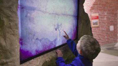 modern entertainment, cute little child draws on a touch screen indoors
