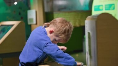 children intellectual development, male child playing on modern learning simulator in museum