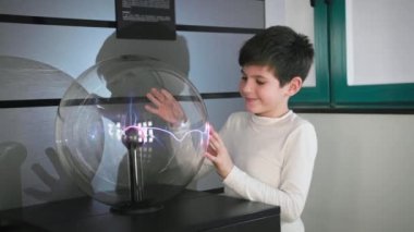 interactive toys, male child playing with plasma ball creating electric waves