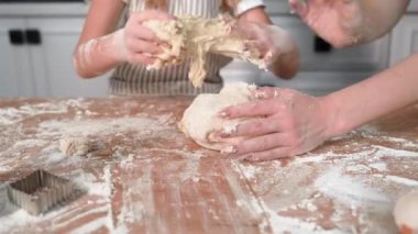 cooking together with parent, caring mother with beloved female child preparing dough for baking at table in kitchen, close-up