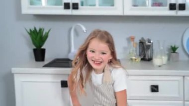 fun cooking, smiling girl is playing and running while cooking and hiding under table, camera moves after child