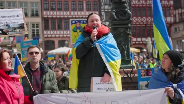 2022年4月10日 法兰克福 支持乌克兰的集会 手里拿着麦克风的黄蓝国旗的妇女抗议对乌克兰人民的种族灭绝 — 图库视频影像