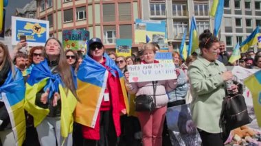 FRANKFURT AM MAIN, Almanya - 10 Nisan 2022: Ulusal bayraklı ve posterli kalabalık, Ukrayna 'nın Rus ordusunun saldırısına Avrupa' nın dikkatini çeken desteğini dile getiriyor