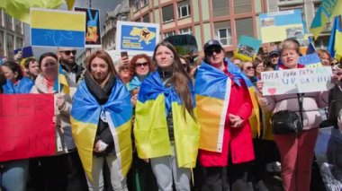 FRANKFURT AM MAIN, ALMAN- 10 Nisan 2022: Ukrayna bayrakları ve posterleri olan insanlar Rus ordusunun saldırganlığını protesto ediyorlar