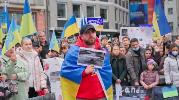 フランクフルト マイン ドイツ エイプリル10 2022年 ウクライナでの戦争に対する集会 ロシア軍による暴力と民間人の殺害に対する抗議活動によって殺された民間人の写真を持つ若い男 — ストック動画