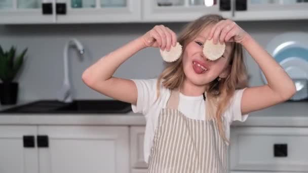 Χαρούμενο Κοριτσάκι Που Διασκεδάζει Φτιάχνοντας Μπισκότα Και Διασκεδάζοντας Βγάζοντας Γλώσσα — Αρχείο Βίντεο