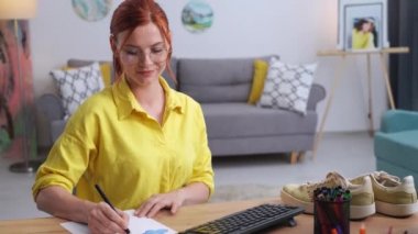 Çekici kadın tasarımcının portreleri, evde sabit bilgisayar başında otururken yaratıcı bir spor ayakkabısı tasarımı için bir baskı çiziyor.