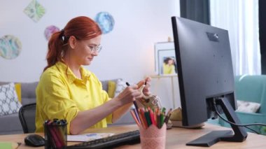 Gözlüklü genç yaratıcı kadının portresi kumaş işaretleri kullanarak spor ayakkabıların üzerinde iz bırakıyor evde bilgisayar başında otururken eşsiz bir tasarım yaratıyor.