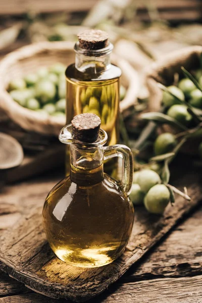 Green olives and olive oil in a bottle close up