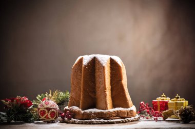 Geleneksel İtalyan Noel pastası Pandoro Noel süsü ve hediyeleri ile. Kapat.