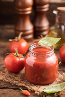 Ev yapımı klasik domates sosu ahşap masaya yakın.