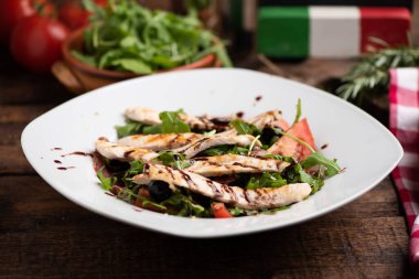 Beyaz tabakta tavuk göğsü ve taze salata.