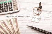 Real Estate Mortgage Application Form with a ring house key close up